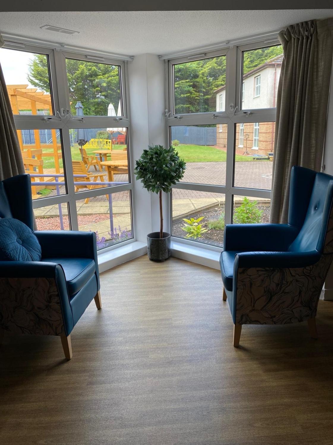 armchairs facing each other next to a large window