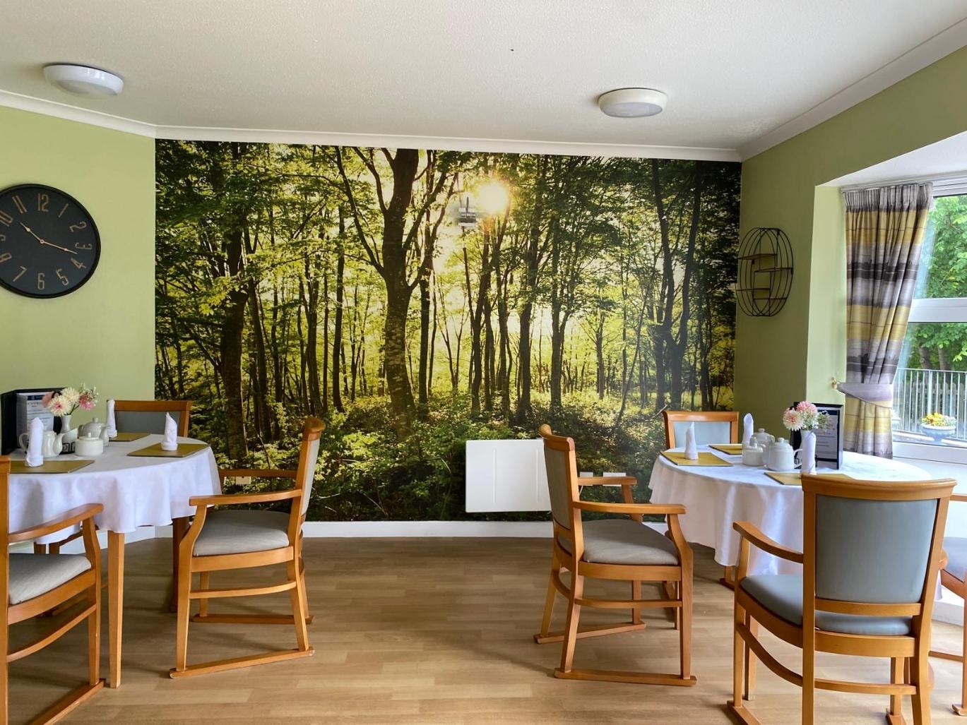 care home dining room with forest wall